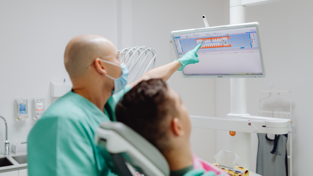 Dentist reviewing digital dental imaging with a patient using advanced technology at Broad St Smiles in San Luis Obispo, CA.