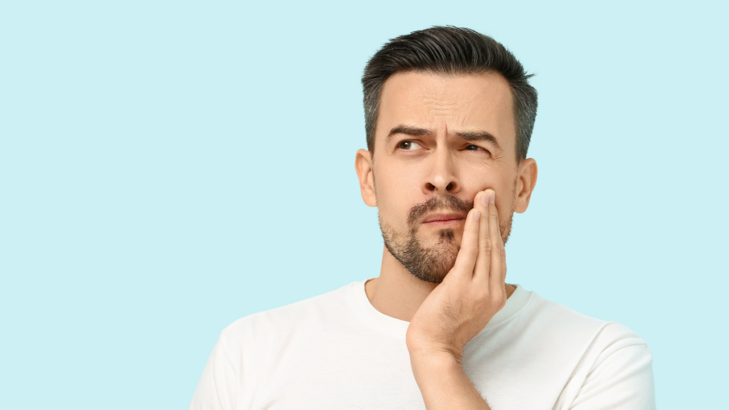 Man experiencing tooth discomfort, highlighting the importance of preventive dental care at Broad St Smiles in San Luis Obispo, CA.
