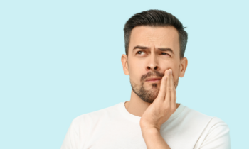 Man experiencing tooth discomfort, highlighting the importance of preventive dental care at Broad St Smiles in San Luis Obispo, CA.